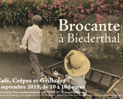 Deux enfants près d'un mur en pierre dans un cadre champêtre et naturel, à la ferme du Geissberg à Biederthal, agriculture biodynamique en circuit court.